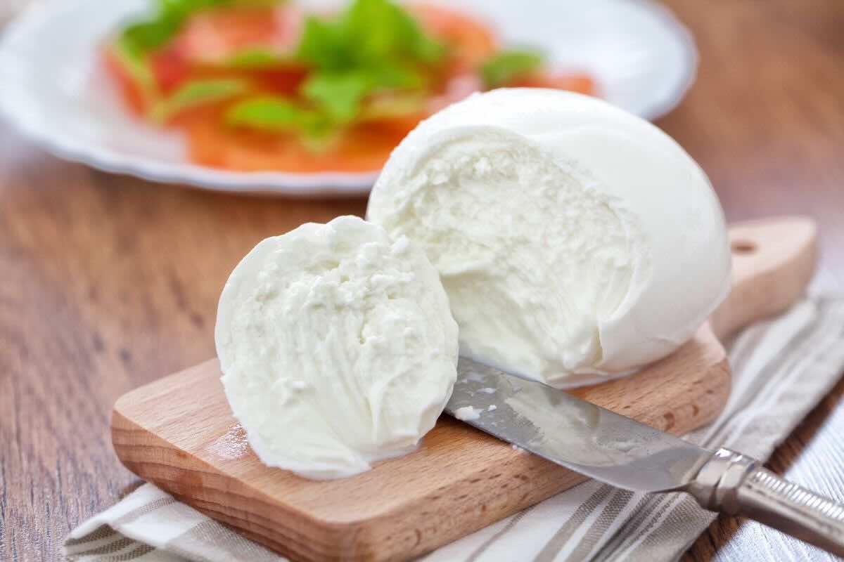 mozzarella di bufala tagliata a metà su un tagliere