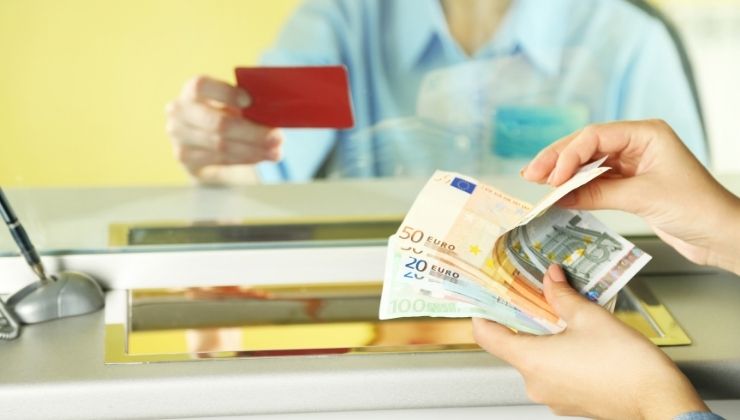 persona conta banconote euro davanti sportello